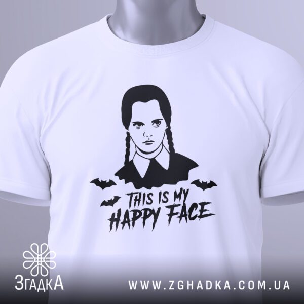 Крупний план принта "This is my happy face" з портретом Венздей Адамс на білій футболці, що детально показує графіку та текст.