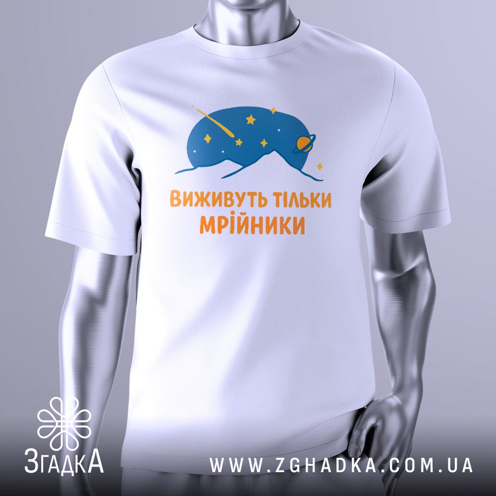 Біла футболка з графічним принтом у центрі. На принті зображено абстрактну, футуристичну істоту або об'єкт у космічному стилі, з текстурою, що нагадує галактику чи зорі. Над нею напис "Виживуть тільки мрійники". Футболка на сірому манекені.