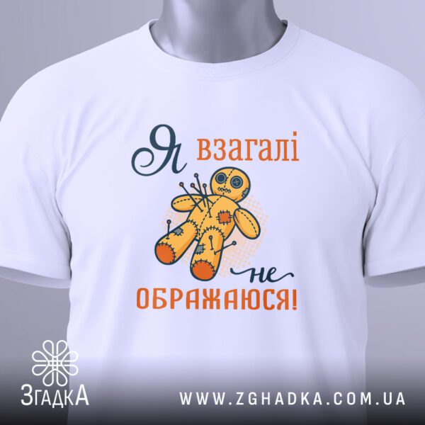 Крупний план принта "я не ображаюся" на білій футболці, що детально показує ляльку-вуду та напис.