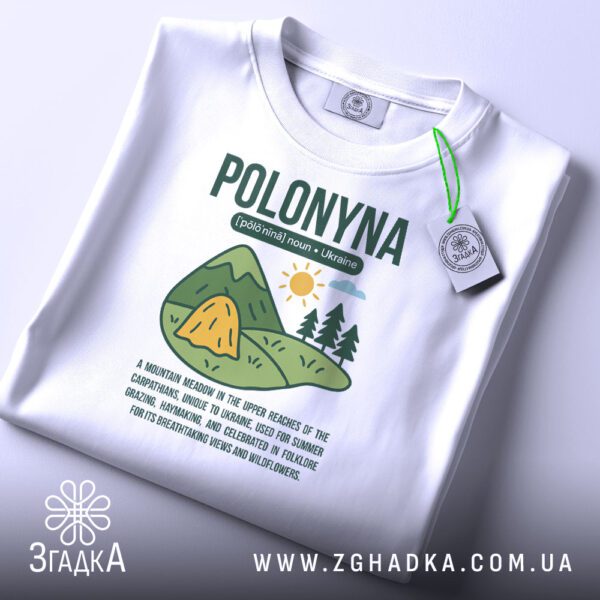 Складена біла футболка з принтом "полонина" та етикеткою "Згадка".