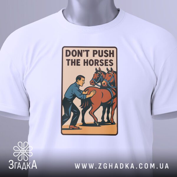 Крупний план принта "Don’t push the horses" на білій футболці, що детально показує зображення чоловіка, що штовхає коней, та текст.