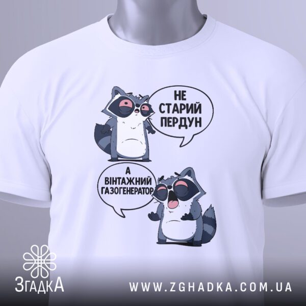Крупний план принта "Не старий пердун, а вінтажний газогенератор" з єнотом на білій футболці, що детально показує графіку та шрифти.