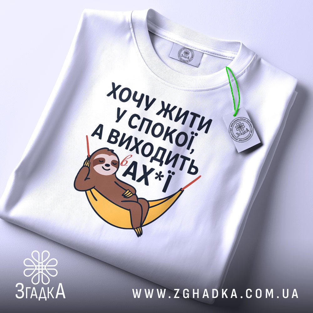 Складена біла футболка з принтом "жити у спокої" та етикеткою "Згадка".