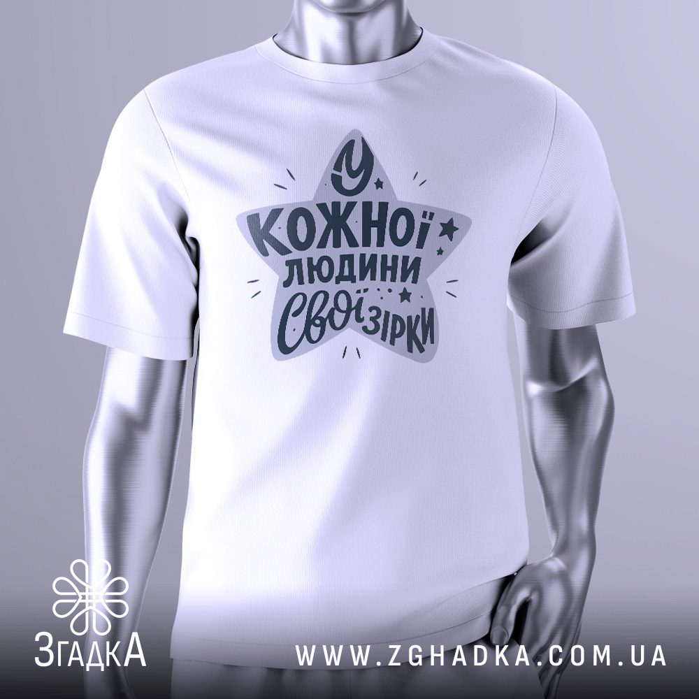 Біла футболка з чорно-білим графічним принтом у вигляді зірки, що складається з ліній та штрихів. У центрі зірки, у кілька рядків, розміщений напис "У кожної людини свої зірки". Футболка на сірому манекені.