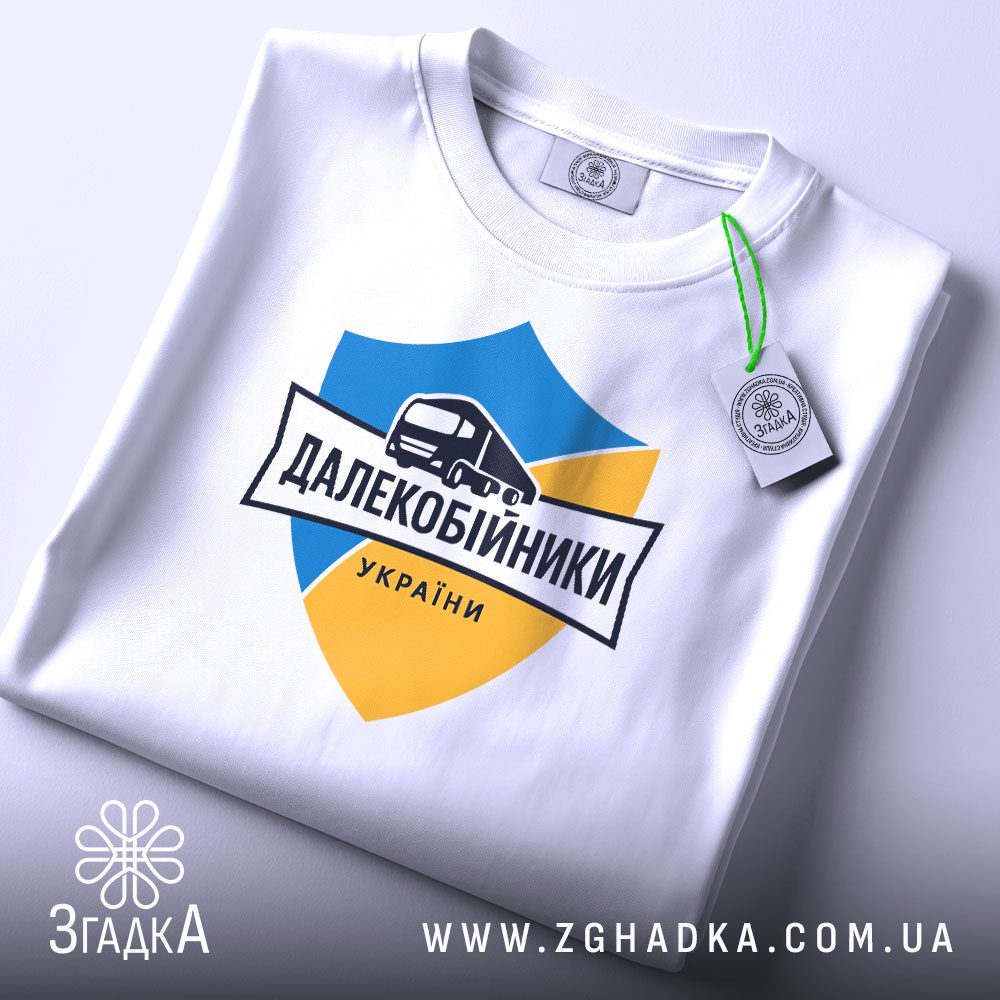 Складена біла футболка з принтом "далекобійники України патріотична" та етикеткою "Згадка".
