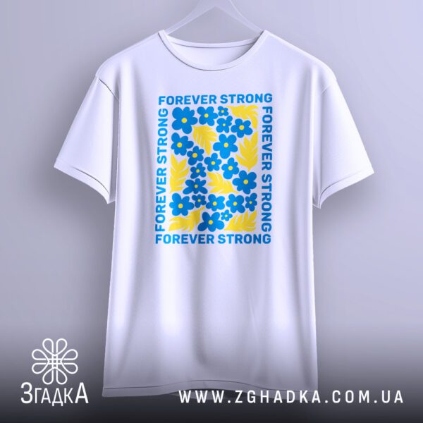 Біла футболка з принтом "forever strong Україна", що висить на білих плічках, демонструючи дизайн.
