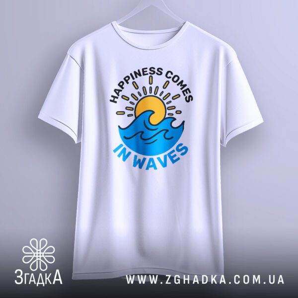 Біла футболка з принтом "happiness comes waves", що висить на білих плічках, демонструючи дизайн.