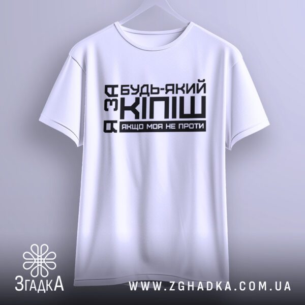 Біла футболка з написом "кіпіш для друзів", що висить на вішаку, демонструючи дизайн.