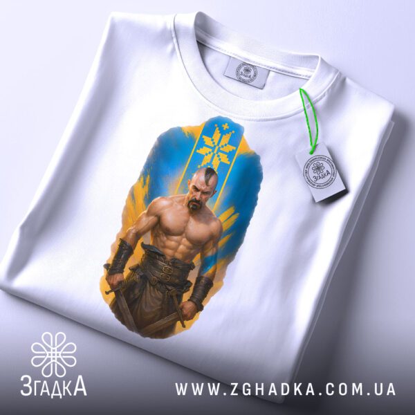 Складена біла футболка з принтом "козацька сила Україна" та етикеткою "Згадка".