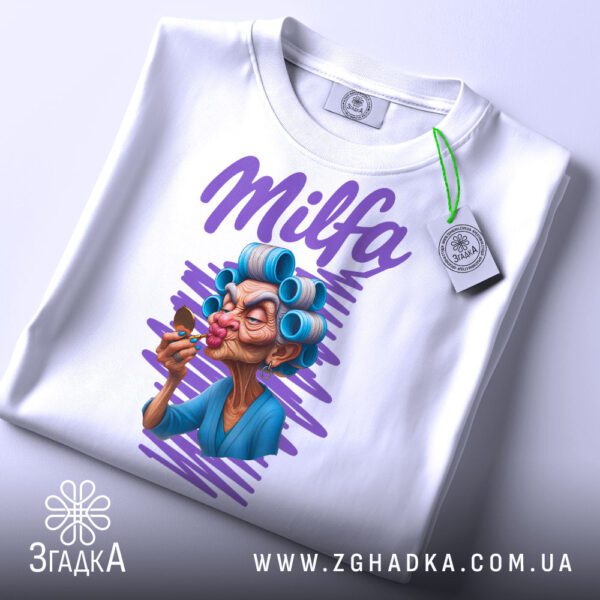 Крупний план принту "Milfa кумедний подарунок" на білій футболці, що детально показує ілюстрацію.