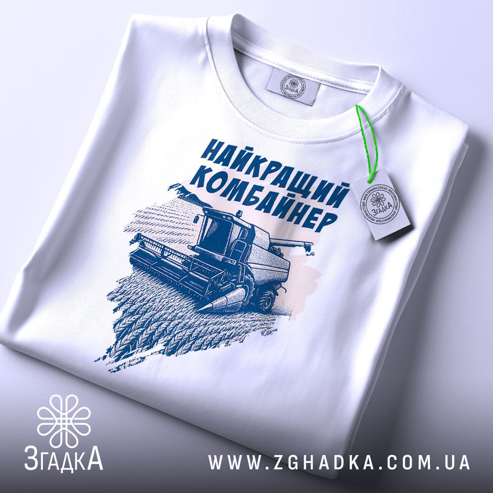 Крупний план принту "найкращий комбайнер подарунок" на білій футболці, що детально показує ілюстрацію.