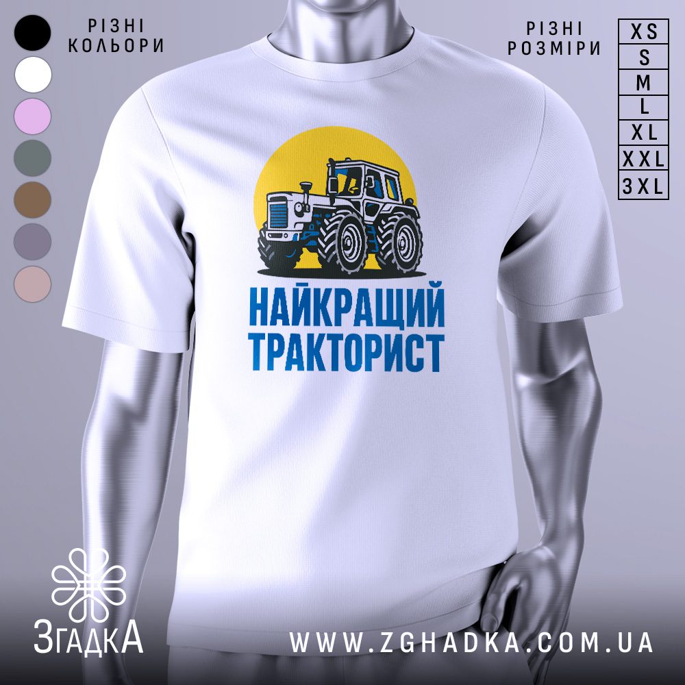 Біла футболка з графічним принтом у центрі. На принті зображено трактор на жовтому колі з написом «НАЙКРАЩИЙ ТРАКТОРИСТ».