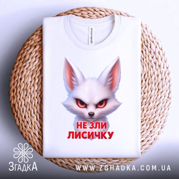 Біла футболка з принтом «не зли лисичку», що висить на вішаку.
