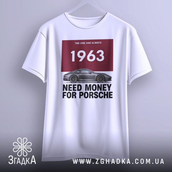 Біла футболка з принтом "Need Money Porsche", що висить на вішаку, демонструючи дизайн.