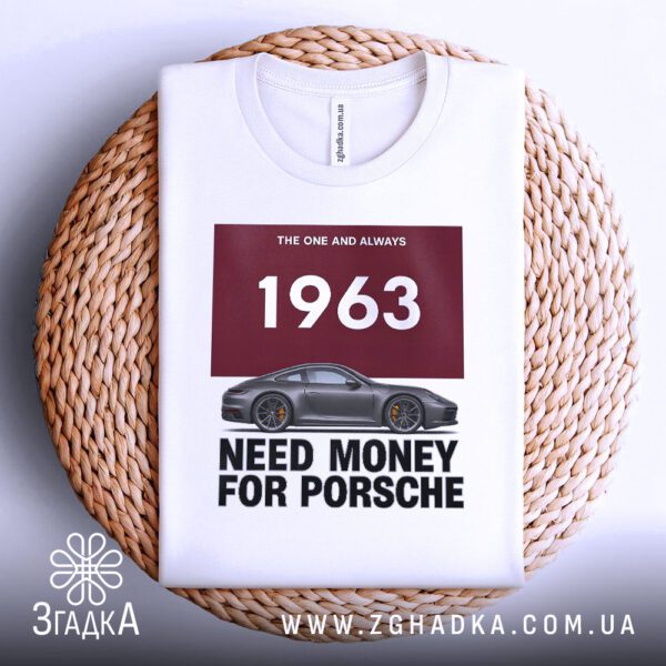 Біла футболка з принтом "Need Money Porsche", складена на світлій поверхні.