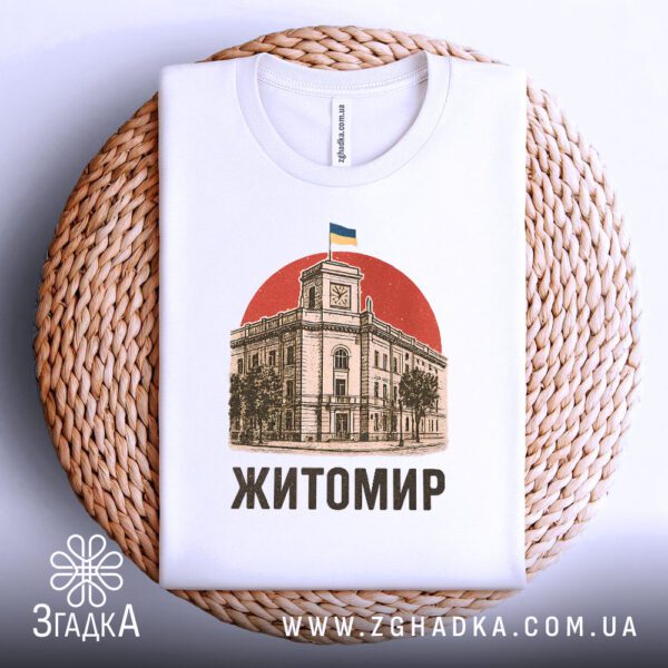 Біла футболка з принтом "патріотична Житомир Україна", складена на світлій поверхні.