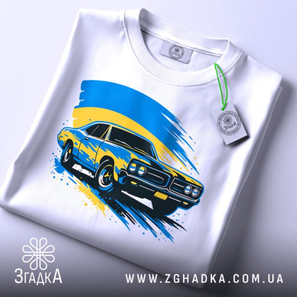 Складена біла футболка з принтом "патріотичне авто Україна" та етикеткою "Згадка".