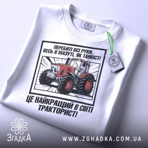 Крупний план принту "подарунок для тракториста" на білій футболці, що детально показує ілюстрацію.