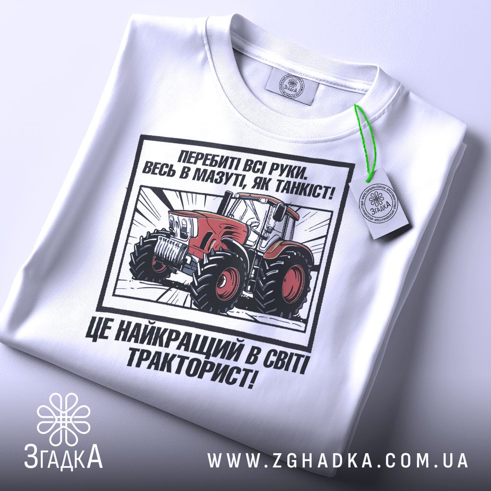 Крупний план принту "подарунок для тракториста" на білій футболці, що детально показує ілюстрацію.