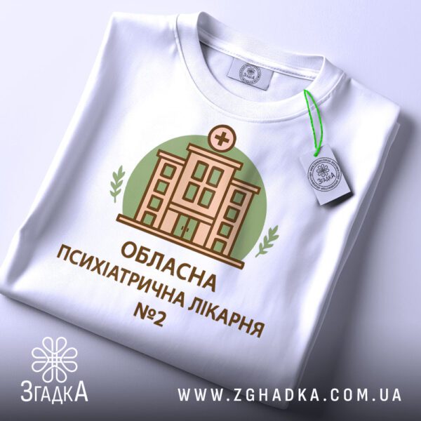 Крупний план принту "психіатрична лікарня" на білій футболці, що детально показує ілюстрацію.