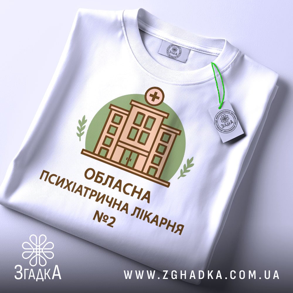 Крупний план принту "психіатрична лікарня" на білій футболці, що детально показує ілюстрацію.