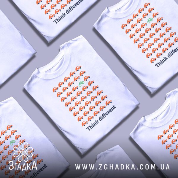 Кілька білих футболок з принтом "think different стиль", складені стопкою або розкладені поруч на світлому фоні.
