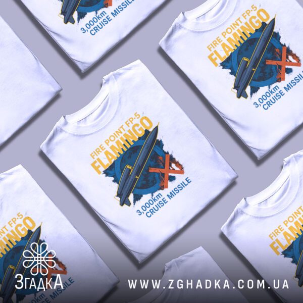 Біла футболка з принтом «Українська ракета Фламінго», складена на поверхні.