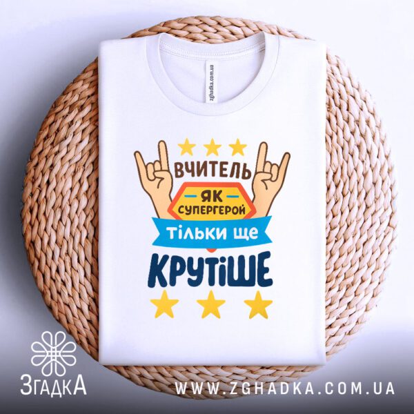 Футболка Вчитель як супергерой, що висить на вішаку.