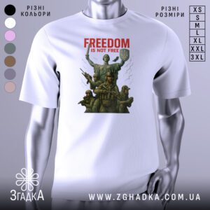 Біла футболка з принтом, що зображає українських воїнів на фоні монумента «Батьківщина-Мати» у Києві з написом “FREEDOM IS NOT FREE”.