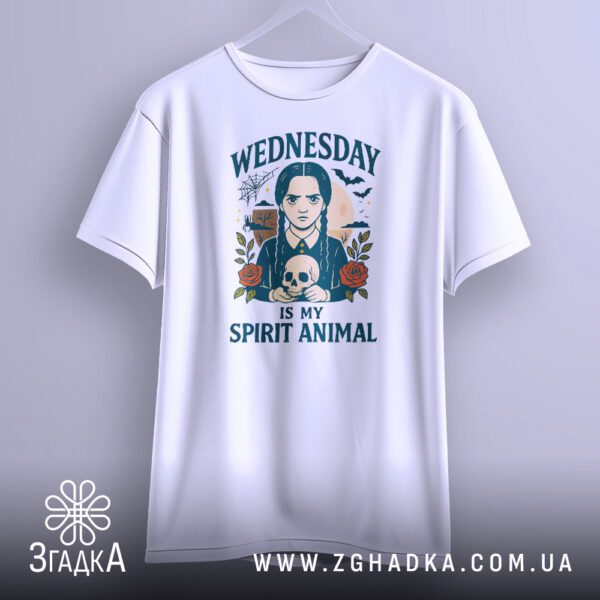 Біла футболка з принтом "Wednesday Adams череп", що висить на білих плічках, демонструючи дизайн.