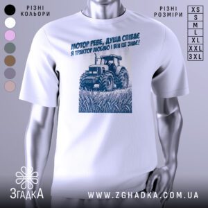 Біла футболка з графічним принтом у центрі. На принті зображено трактор у полі з текстом.