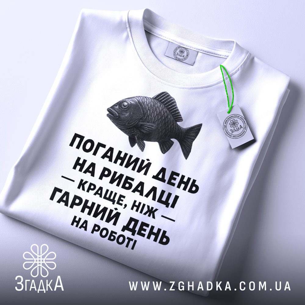 Крупний план напису "з написом рибалка" на білій футболці, що детально показує текст і рибу.