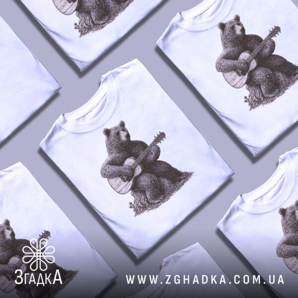 Фотографія білої футболки з принтом "ведмідь гітарист" на моделі.
