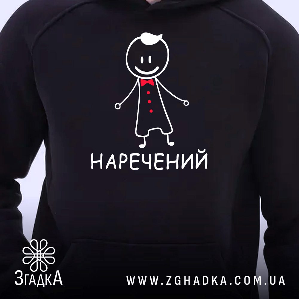 Чорне худі з принтом «Наречений», що висить на вішаку, демонструючи дизайн.