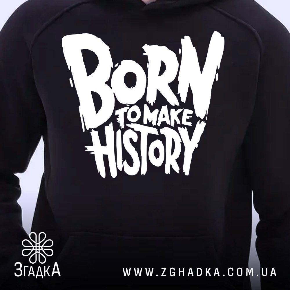 Крупний план принту "BORN TO MAKE HISTORY" на чорному худі, що детально показує ілюстрацію.