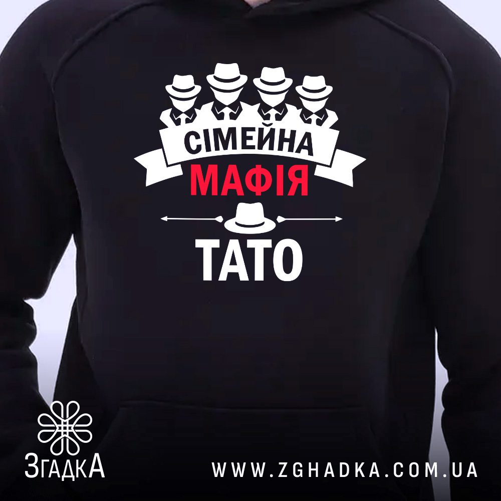 Чорне худі з принтом «Сімейна мафія — тато», що висить на вішаку, демонструючи дизайн.