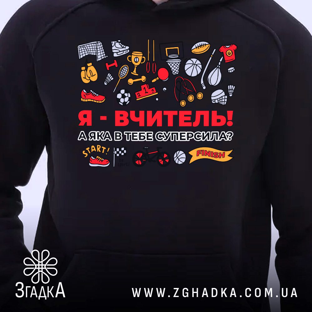 Чорне худі з принтом «Я – ВЧИТЕЛЬ! А яка в тебе суперсила?», що висить на вішаку, демонструючи дизайн.