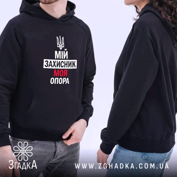 Чорне худі з патріотичним принтом, складене на світлій поверхні.