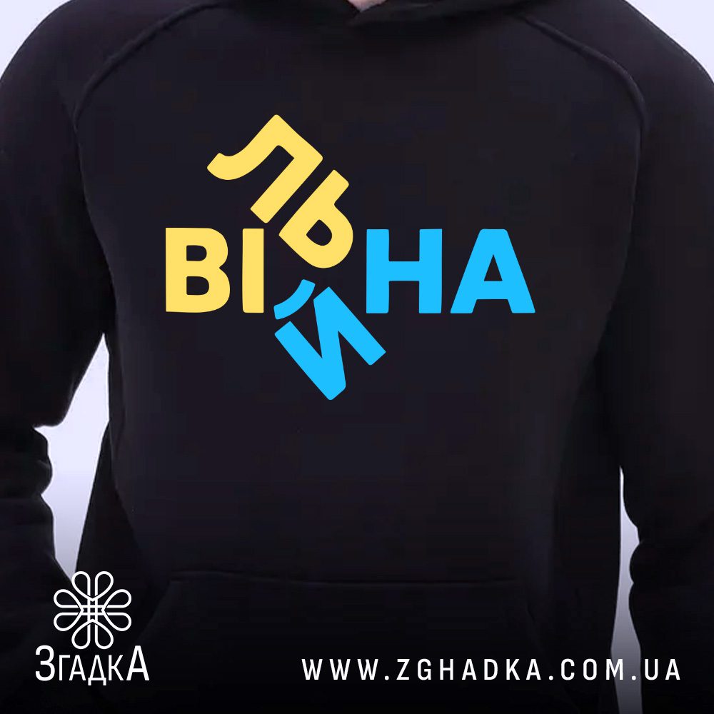 Чорне худі з графічним принтом у центрі. На принті зображено слово "Вільна" у жовто-блакитних кольорах зі зміщеними літерами.