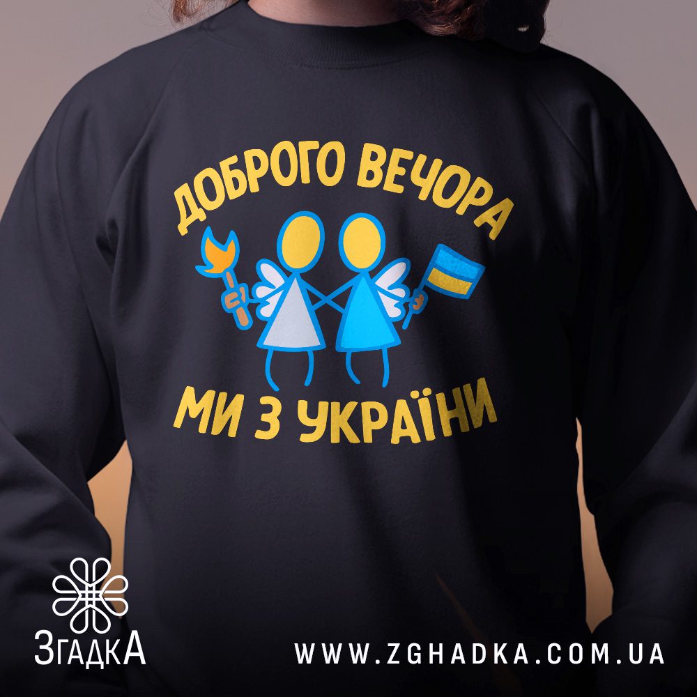 Крупний план принту "доброго вечора Україна" на чорному світшоті, що детально показує ілюстрацію.