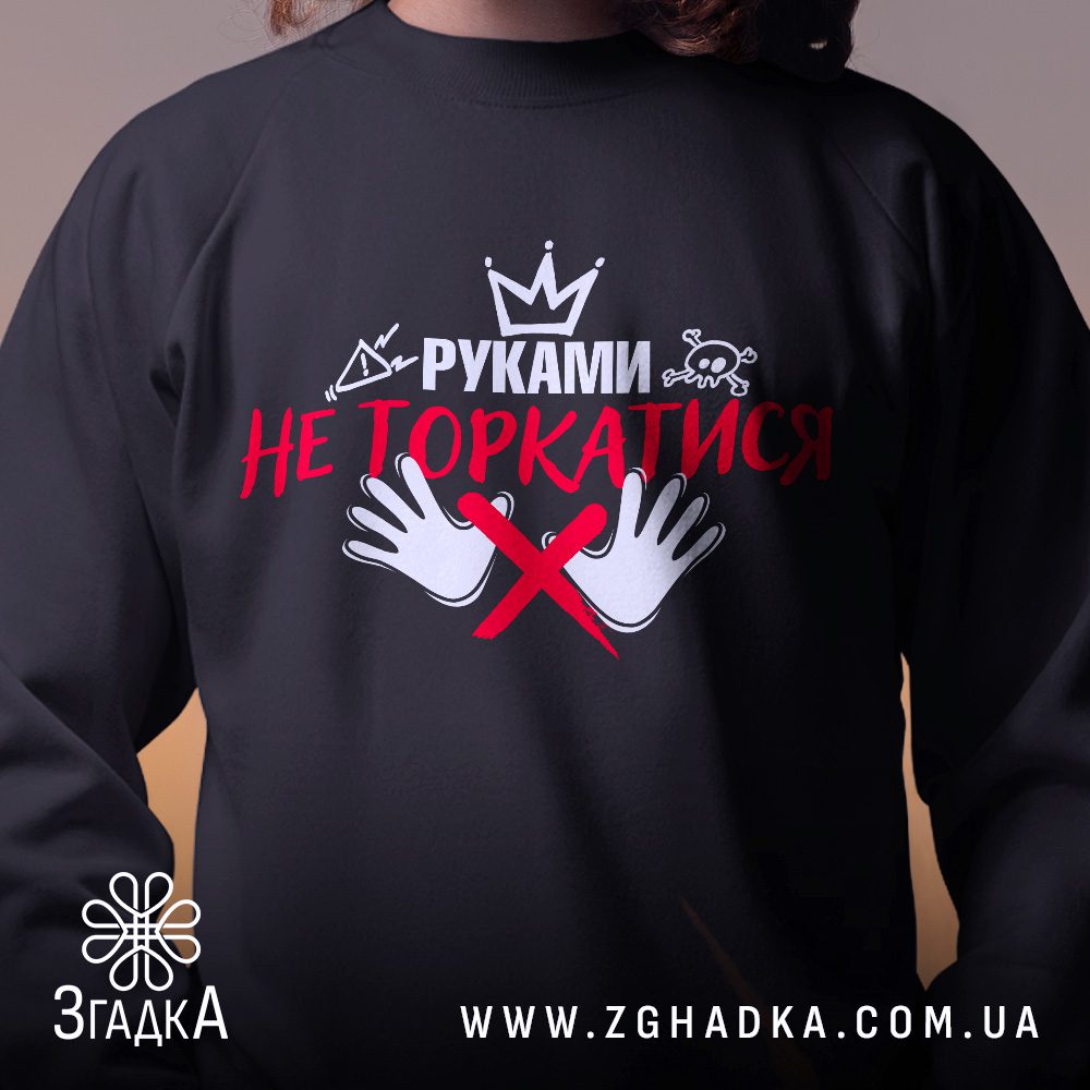 Крупний план принту "руками не торкатись" на чорному світшоті, що детально показує ілюстрацію.
