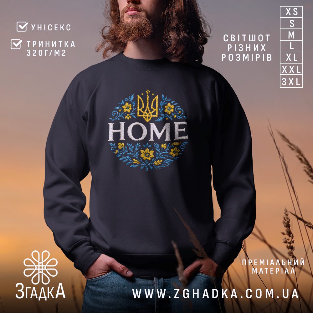 Чорний світшот з графічним принтом у центрі. На принті зображено слово "HOME" під золотим тризубом, оточене синьо-жовтим квітковим орнаментом.