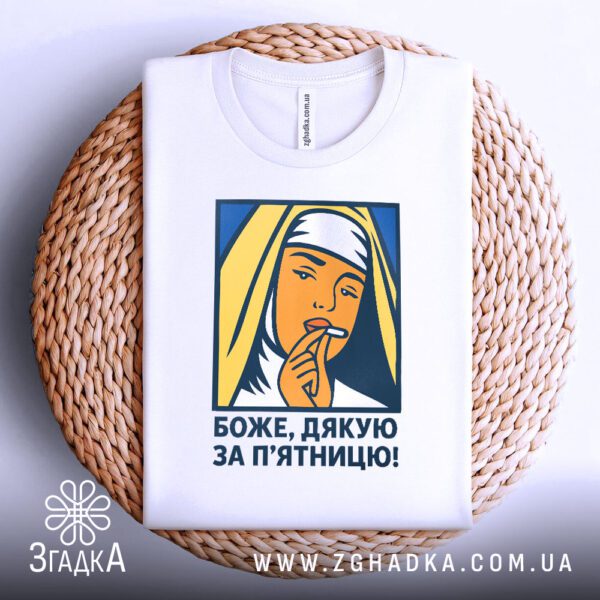 Футболка боже дякую п’ятниця складена на плетеній підставці, вид зверху.