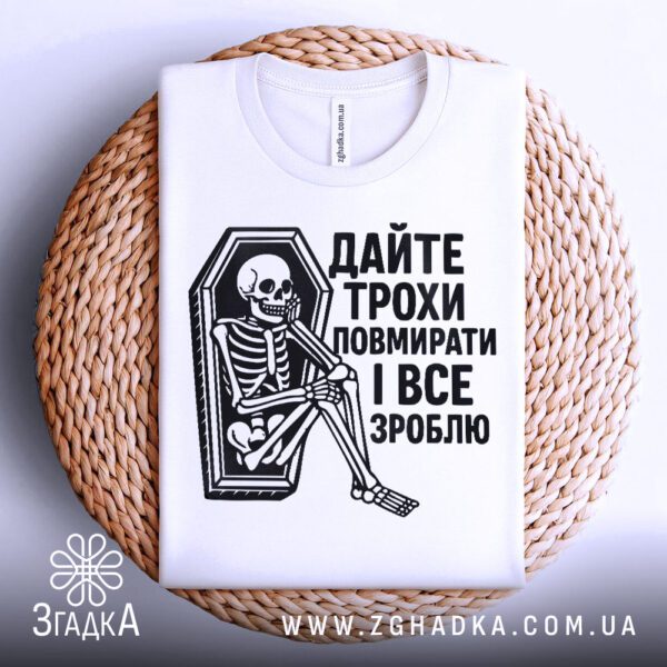 Біла футболка з принтом "Дайте трохи повмирати", складена.