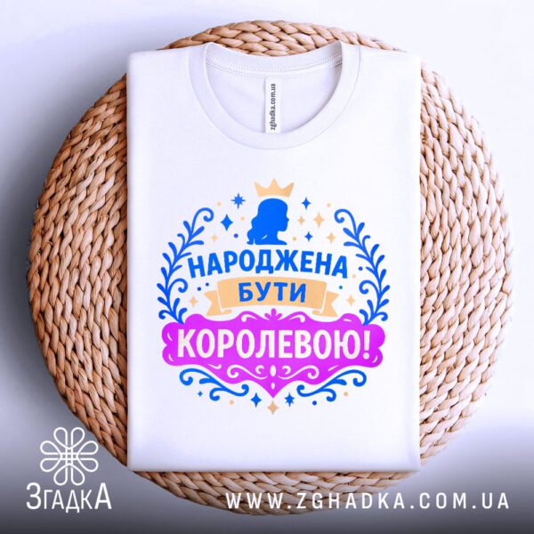 Біла футболка з принтом, складена.
