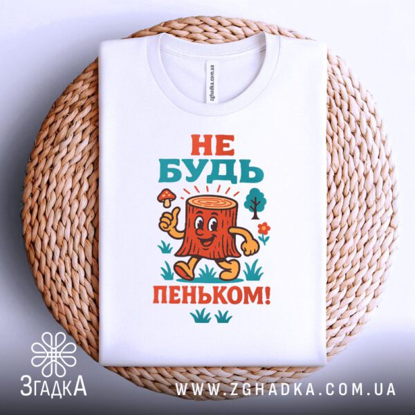 Біла футболка з принтом "Не будь пеньком!", складена.