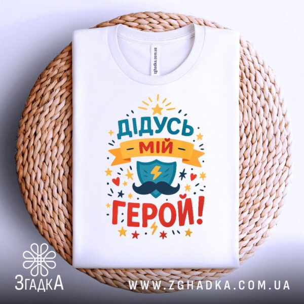 Біла футболка з принтом, складена.