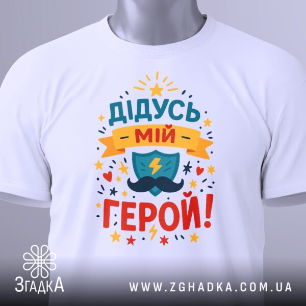 Біла футболка з принтом "Дідусь мій герой!" у пакеті.