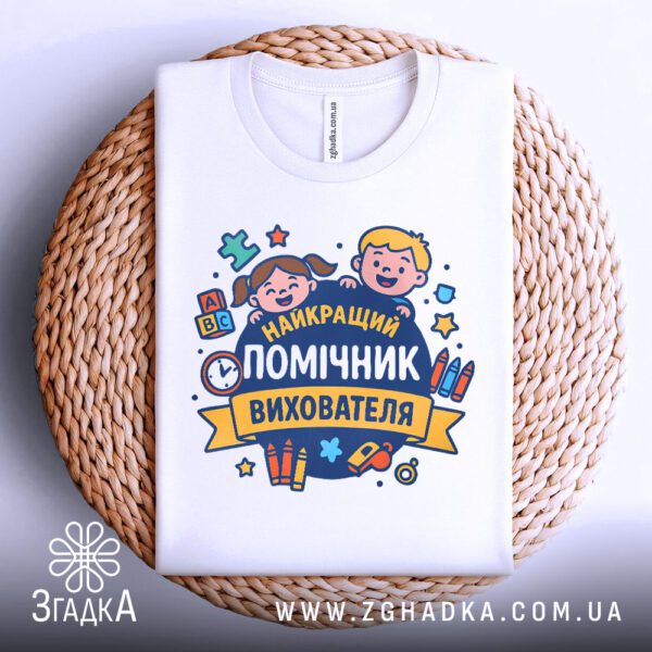 Футболка подяка помічнику вихователя складена на плетеній підставці.