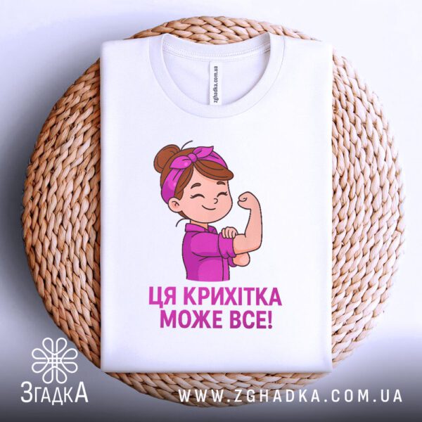 Біла футболка з принтом "Крихітка смілива", складена.